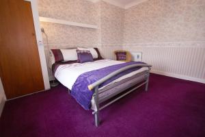 a bedroom with a bed with a purple carpet at Sea Haven Northumberland in Seahouses