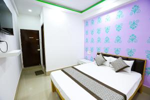 a bedroom with a bed and a purple wall at HOTEL GOLDEN CITY in Surat