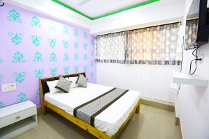 a bedroom with a bed with purple walls at HOTEL GOLDEN CITY in Surat +38 photos