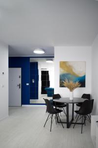 a dining room with blue walls and a table and chairs at Iulius Town Residence in Timişoara