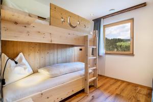 a bedroom with bunk beds and a window at Haughof Apartement Blumenwiese in Verano