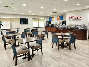 a restaurant with tables and chairs and a kitchen at Comfort Inn & Suites Augusta Fort Eisenhower Area in Augusta