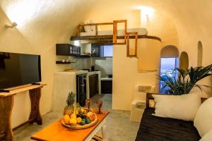 een woonkamer met een tafel met een fruitschaal bij Exi Castle Suites in Emporio