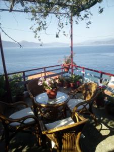 une terrasse avec une table et des chaises et l'océan dans l'établissement Georgia's, à Ayía Kiriakí