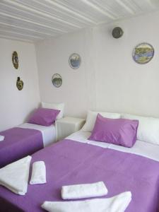 - 2 lits dans une chambre de couleur violette et blanche dans l'établissement Georgia's, à Ayía Kiriakí