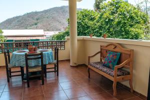 a patio with a table and chairs on a balcony at Casa SanMar cerca de la playa in Yelapa