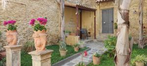 uma casa de pedra com dois vasos com flores em Giardinetto Papale, centralissimo em Caltagirone