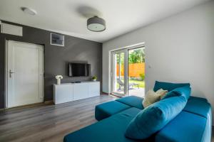 a blue couch in a living room with a tv at MyFlat Villa Nuvola in Siófok