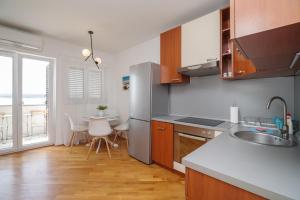 a kitchen with a sink and a table with chairs at Apartment Beta in Crikvenica