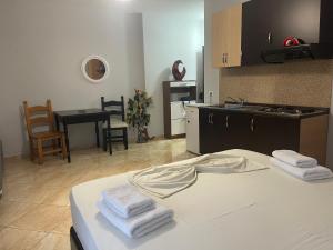 a room with a kitchen and a bed with towels on it at Kokomani in Durrës