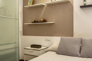 ein Schlafzimmer mit einem Bett und einem Regal an der Wand in der Unterkunft Apartamento en la playa 105 in Guanarteme