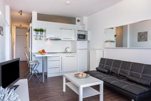 ein Wohnzimmer mit Couch und Küche in der Unterkunft Apartamento en la playa 105 in Guanarteme