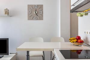 eine Küche mit einem Tisch und einer Uhr an der Wand in der Unterkunft Apartamento en la playa 105 in Guanarteme