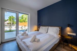 a bedroom with a large bed with a large window at MyFlat Villa Nuvola in Siófok +138 photos