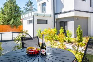 a bottle of beer and a bowl of fruit on a table at MyFlat Villa Nuvola in Siófok