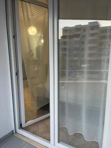 a sliding glass window with a view of a building at Kokomani in Durrës
