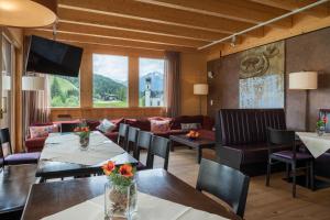 ein Wohnzimmer mit einem Tisch, Stühlen und einem Sofa in der Unterkunft Hotel Wetterstein Seefeld in Seefeld in Tirol