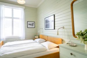 a bedroom with a bed and a desk with a mirror at Sommerhotellet in Vang I Valdres