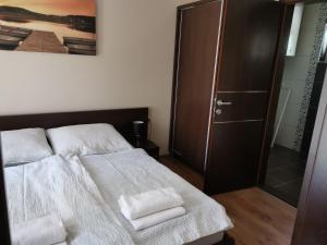 een slaapkamer met een bed met twee handdoeken erop bij Panyi Apartman in Siófok