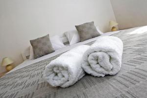 ein Bett mit zwei großen weißen Handtüchern drauf in der Unterkunft Apartmani Cili in Miletići