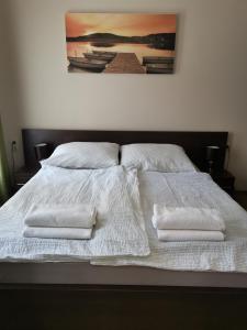 シオーフォクにあるPanyi Apartmanの白いベッド(白いタオル2枚付)