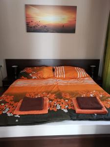 een bed met twee dekens en twee handdoeken erop bij Panyi Apartman in Siófok