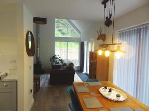 a living room with a wooden table and a dining room at Sawmill Cottage in Grantown on Spey