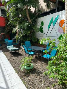eine Terrasse mit Stühlen und einem Tisch mit einem Gemälde an der Wand in der Unterkunft Zebulo Hostel in Panama-Stadt