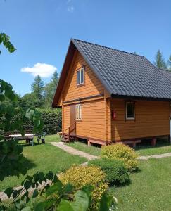 a wooden cabin with a bench in a yard at Willa Kamieniec in Polańczyk