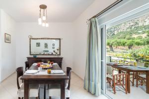 a dining room with a table and a large window at Haris Villas in Keratokampos +35 photos