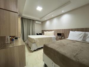 Habitación de hotel con 2 camas y escritorio en Ponta Negra Beach Apts 507 e 501, en Natal