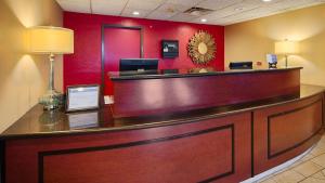 a reception desk in a hotel lobby with a red wall at Inn at Coushatta in Kinder