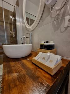 La salle de bains est pourvue d'un lavabo et d'une baignoire sur un comptoir en bois. dans l'établissement Dimora Giusti, à Lecce