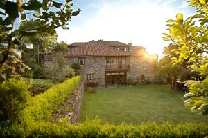 a large stone house with a garden in front of it at Casa Rural Cordobelas in Cedeira