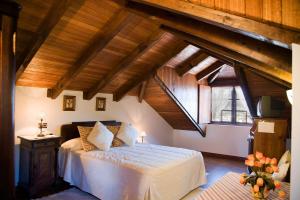 een slaapkamer met een bed in een kamer met houten plafonds bij Casa Rural Cordobelas in Cedeira