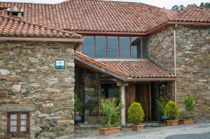 ein Steinhaus mit rotem Dach in der Unterkunft Casa Rural Cordobelas in Cedeira + 6 Fotos