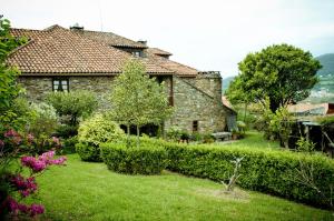 una antigua casa de piedra con jardín en Casa Rural Cordobelas, en Cedeira