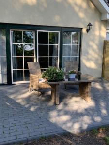 um pátio com duas cadeiras e uma mesa com plantas em Schicke neue Ferienwohnung em Bremen