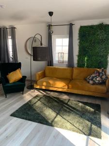 uma sala de estar com um sofá castanho e uma parede verde em Schicke neue Ferienwohnung em Bremen