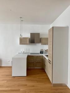 Biała kuchnia z drewnianą podłogą i białą lodówką w obiekcie Quartiere 11 w mieście Vicenza