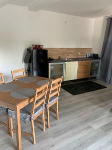 uma cozinha com uma mesa de madeira e cadeiras num quarto em Schicke neue Ferienwohnung em Bremen