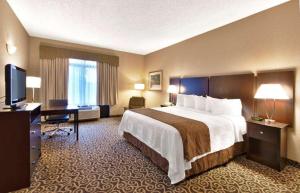 a hotel room with a large bed and a desk at Inn at Coushatta in Kinder
