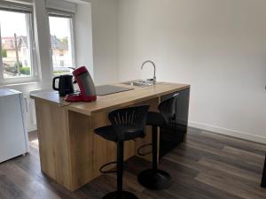 a kitchen with a desk with a sink and a chair at Le 33 L’Idéal in Belfort
