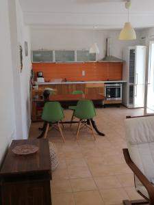 a kitchen with a table and green chairs at George's house in Giannádes