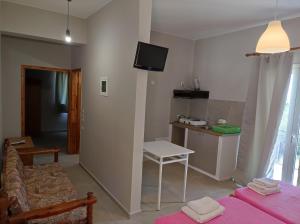 a living room with a couch and a tv on the wall at San Pedro in Vasiliki