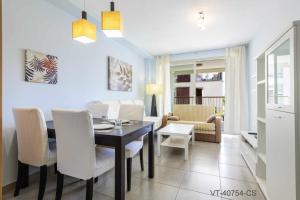 a dining room with a table and white chairs at Apartamento en Residencial Aldea Golf Panorámica in San Jorge