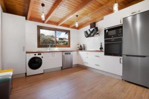 a kitchen with white appliances and a wooden ceiling at Casa Milagrito Betancuria in Betancuría