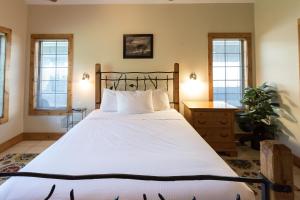 Un dormitorio con una gran cama blanca y ventanas. en Interlachen Unit 4, en Nisswa 20 fotos más