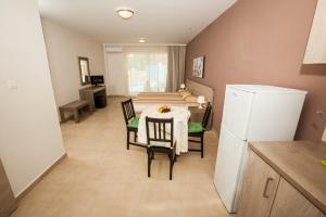 eine Küche und ein Esszimmer mit einem Tisch und einem Kühlschrank in der Unterkunft Crystallo Apartments in Paphos City