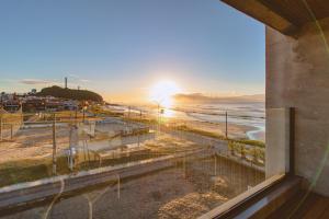 vista para a praia ao pôr-do-sol a partir de um edifício em BALUARTE POUSADA em Torres